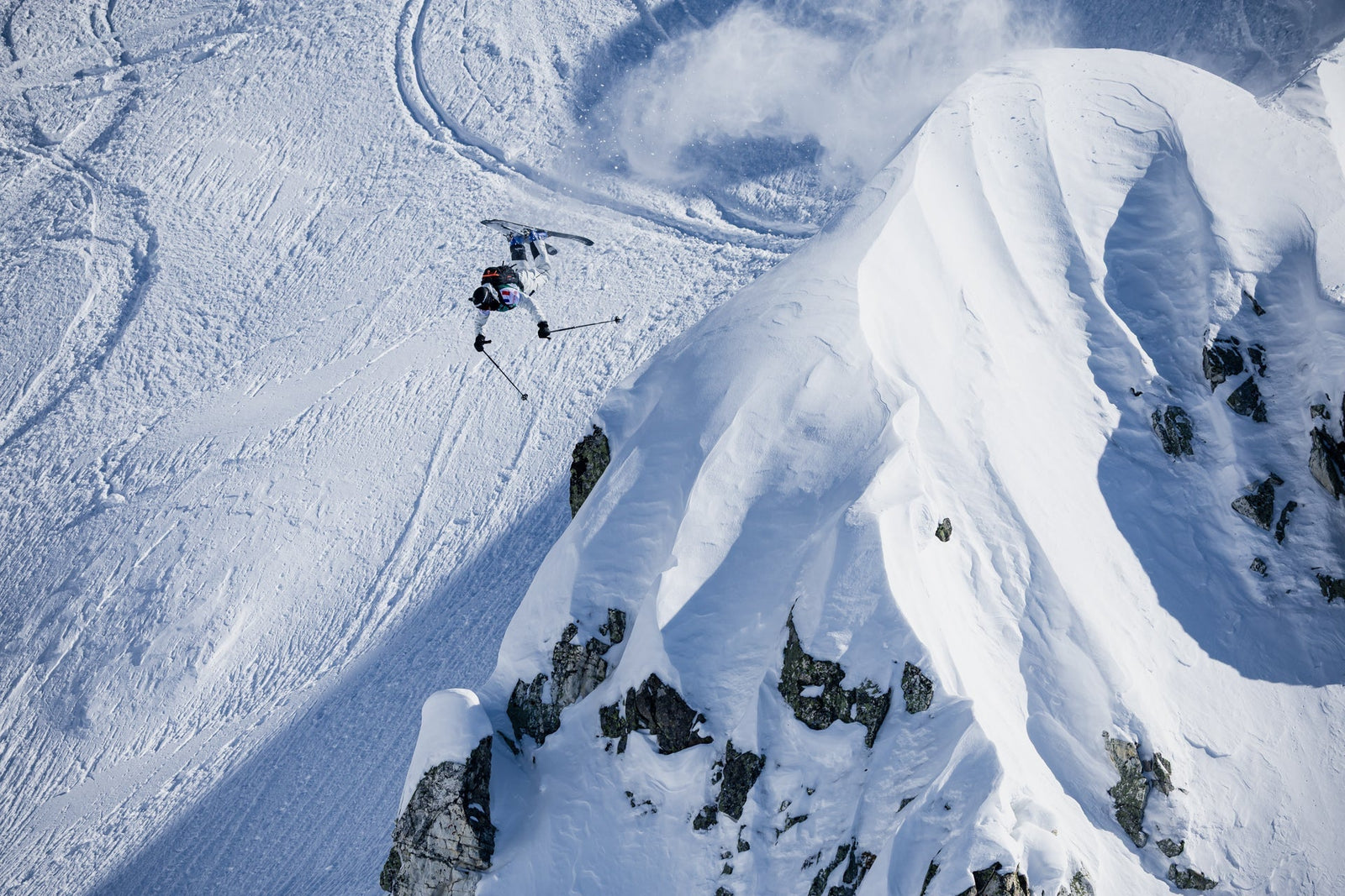 DOWN skis ambassador Mathys throwing a huge backflip over a pyramid shaped rock with lots of snow